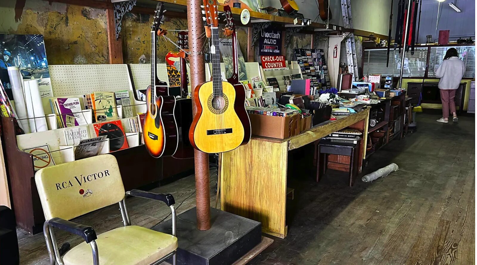 Inside The Gist Music Company — instrument wall and RCA Victor chair